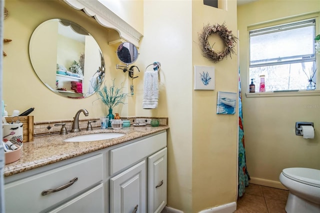 full bath with toilet, tile patterned flooring, baseboards, and vanity