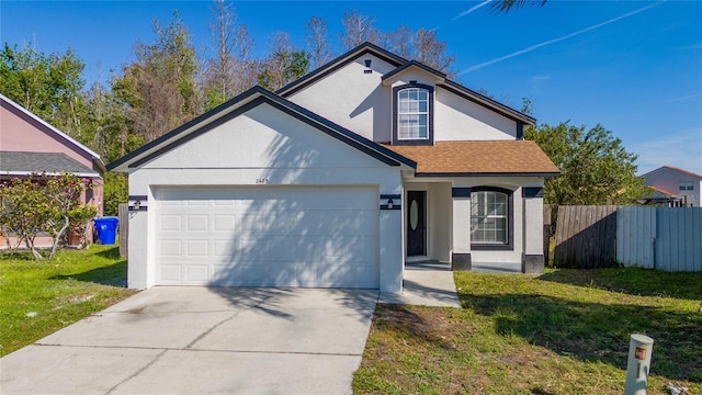 traditional home featuring stucco siding, an attached garage, a front yard, fence, and driveway