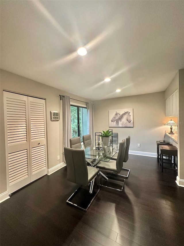 dining room featuring baseboards, wood finished floors, and recessed lighting