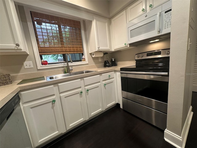 kitchen with a sink, appliances with stainless steel finishes, white cabinets, and light countertops