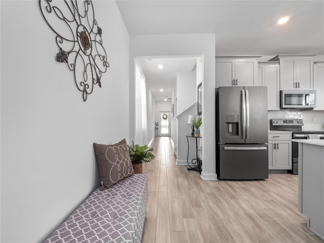 9747 Petition Way, Orlando, FL 32832 - kitchen featuring stainless steel appliances, light wood finished floors, baseboards, and decorative backsplash