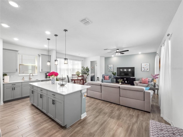 9747 Petition Way, Orlando, FL 32832 - kitchen featuring light countertops, a sink, gray cabinetry, and light wood finished floors