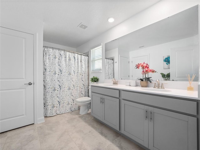 9747 Petition Way, Orlando, FL 32832 - bathroom featuring toilet, double vanity, a sink, and visible vents