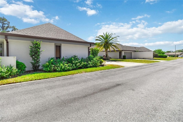 1489 Magellan Cir Unit 603, Orlando, FL 32818 - view of front of house featuring concrete driveway, stucco siding, and roof with shingles