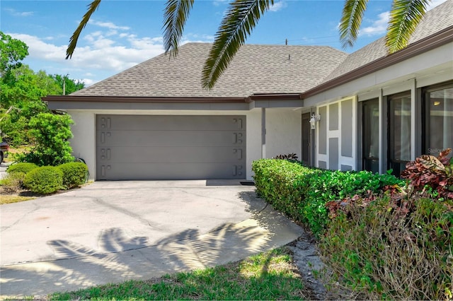 1489 Magellan Cir Unit 603, Orlando, FL 32818 - view of front of house featuring stucco siding, an attached garage, a shingled roof, and concrete driveway