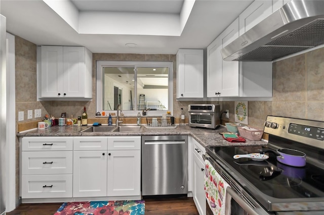 1489 Magellan Cir Unit 603, Orlando, FL 32818 - kitchen with wall chimney range hood, a sink, stainless steel appliances, and white cabinetry