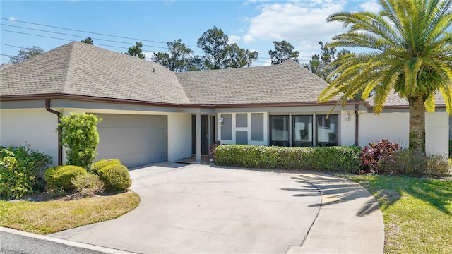 1489 Magellan Cir Unit 603, Orlando, FL 32818 - view of front of property with a shingled roof, driveway, stucco siding, and an attached garage