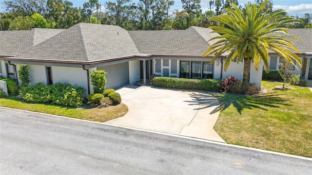 1489 Magellan Cir Unit 603, Orlando, FL 32818 - view of front of home with driveway, an attached garage, a front yard, stucco siding, and a shingled roof
