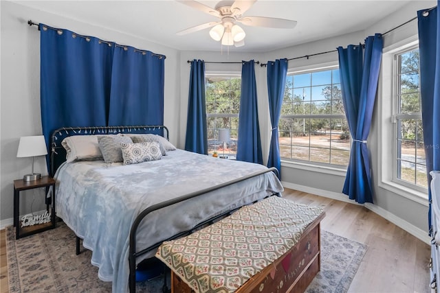 bedroom featuring wood finished floors, a ceiling fan, and baseboards