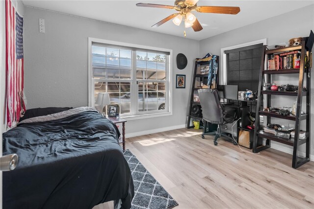 bedroom with ceiling fan, baseboards, and wood finished floors