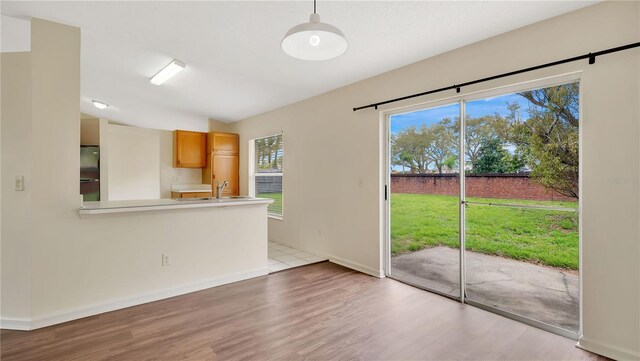 interior space with a sink, baseboards, vaulted ceiling, and wood finished floors