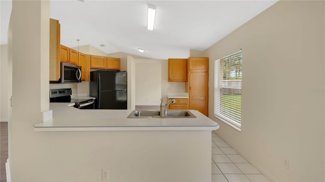 kitchen with light tile patterned floors, a sink, vaulted ceiling, light countertops, and appliances with stainless steel finishes