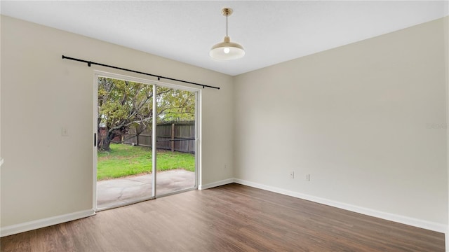 unfurnished room featuring baseboards and wood finished floors