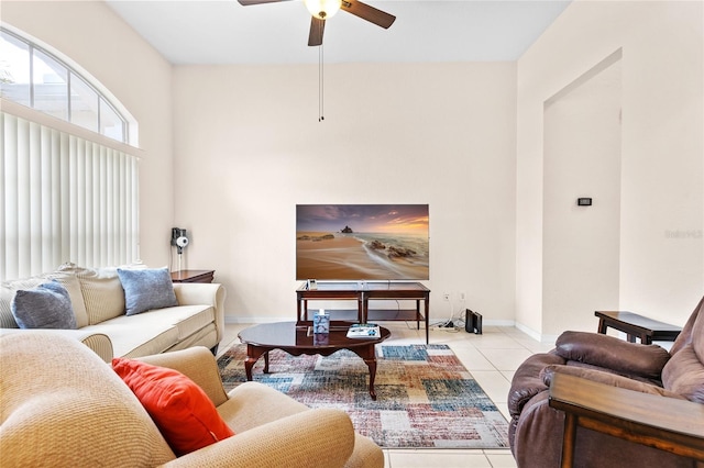 living area with baseboards, a ceiling fan, and tile patterned floors