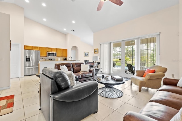 living room with arched walkways, ceiling fan, high vaulted ceiling, light tile patterned flooring, and recessed lighting