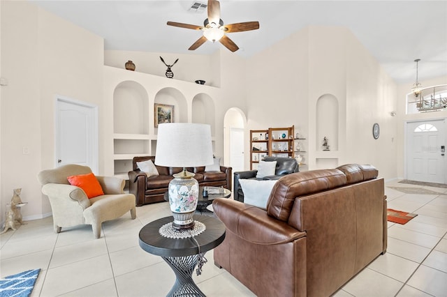 living room with light tile patterned floors, built in shelves, visible vents, and arched walkways