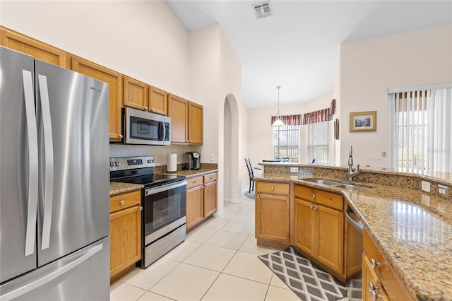 kitchen with light tile patterned floors, visible vents, arched walkways, appliances with stainless steel finishes, and a sink