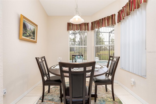 dining space featuring light tile patterned floors and baseboards