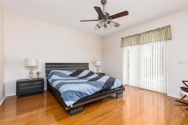 bedroom featuring access to exterior, ceiling fan, baseboards, and wood finished floors