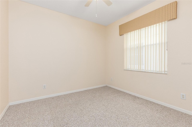 unfurnished room with a ceiling fan, baseboards, and carpet flooring