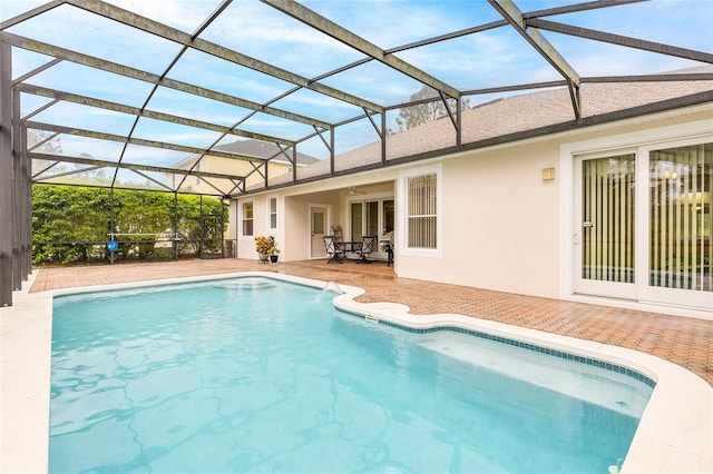 pool with a ceiling fan, glass enclosure, and a patio