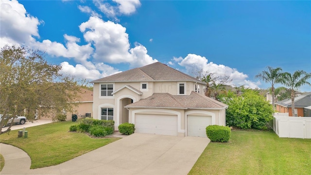 view of front facade with driveway, an attached garage, fence, and a front yard