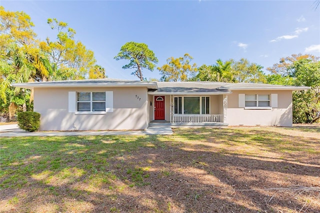 single story home featuring stucco siding, a porch, and a front lawn