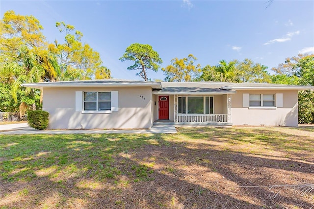 ranch-style house with covered porch, stucco siding, and a front yard