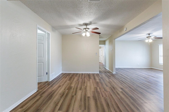 unfurnished room with visible vents, wood finished floors, baseboards, and ceiling fan