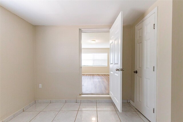 interior space with light tile patterned floors and baseboards