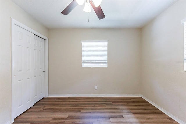 unfurnished bedroom featuring a closet, ceiling fan, baseboards, and wood finished floors