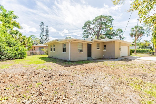 back of house featuring fence, a garage, and driveway