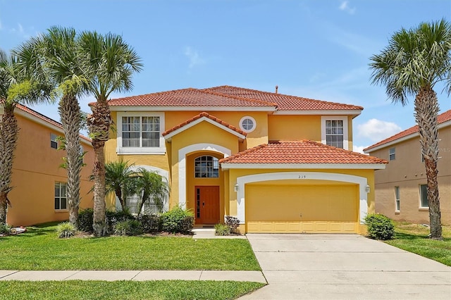 mediterranean / spanish house with an attached garage, driveway, a front yard, and stucco siding