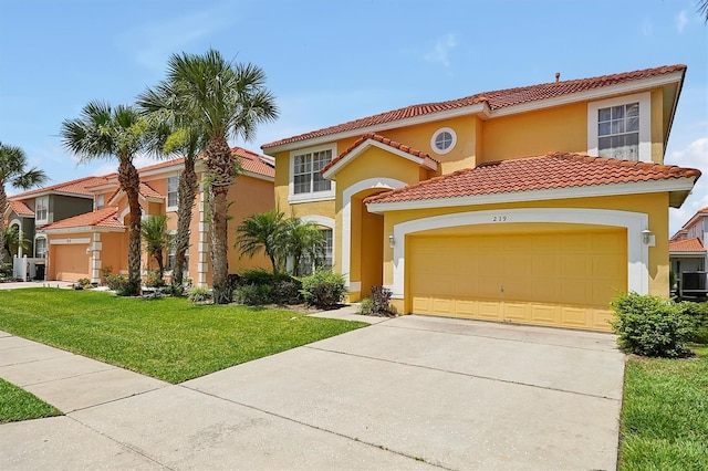 mediterranean / spanish-style house with a tile roof, stucco siding, concrete driveway, an attached garage, and a front yard