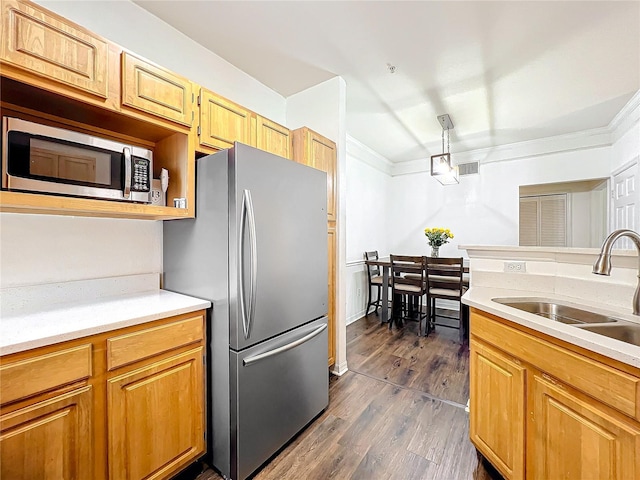 kitchen with stainless steel appliances, light countertops, visible vents, and a sink