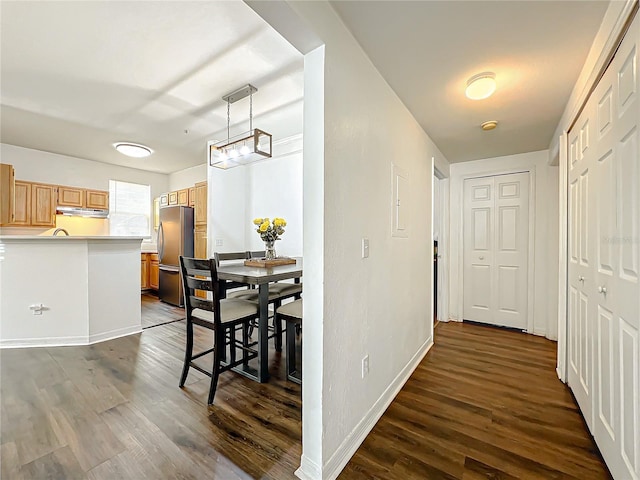 hall with dark wood-type flooring and baseboards