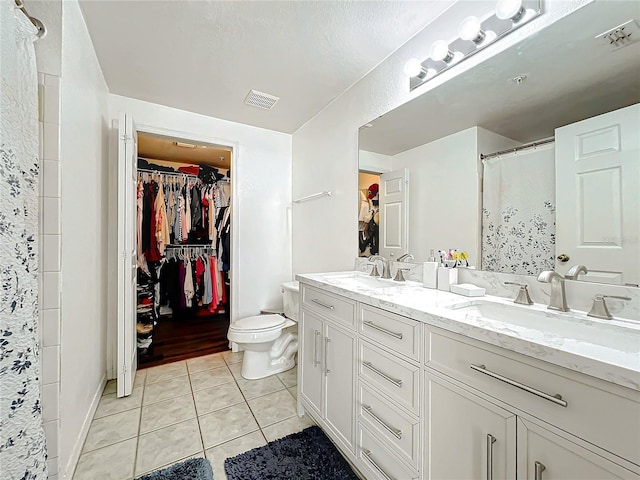 bathroom featuring double vanity, visible vents, a sink, and tile patterned floors