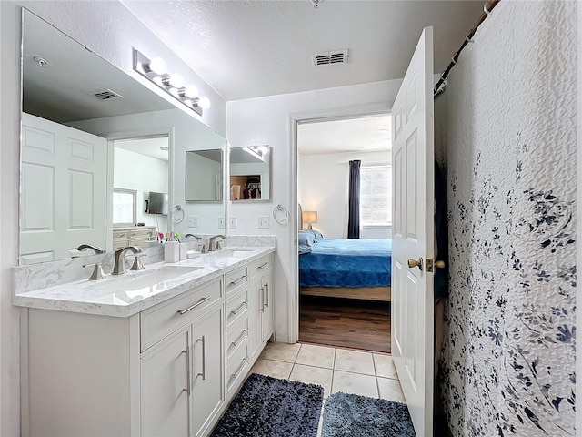 ensuite bathroom featuring visible vents, a sink, ensuite bathroom, and tile patterned floors