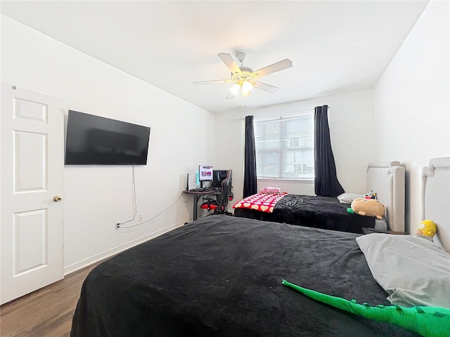 bedroom featuring ceiling fan, baseboards, and wood finished floors