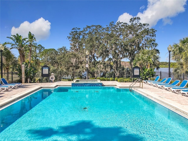 community pool featuring fence and a patio