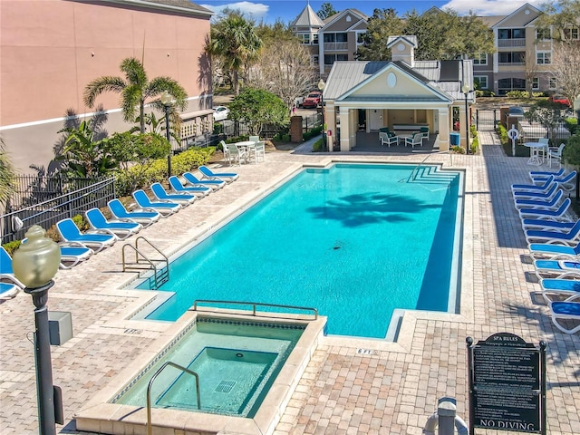 pool with a community hot tub, a patio, and fence