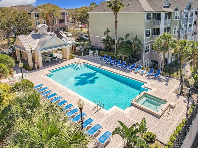 view of pool with a pool with connected hot tub, fence, a patio, and a gazebo