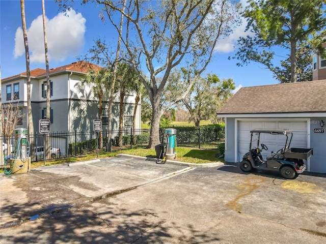 view of vehicle parking with a garage and fence