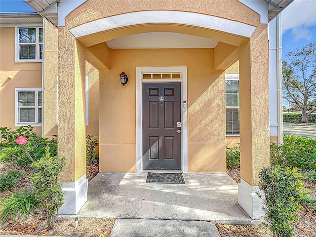 view of exterior entry featuring stucco siding