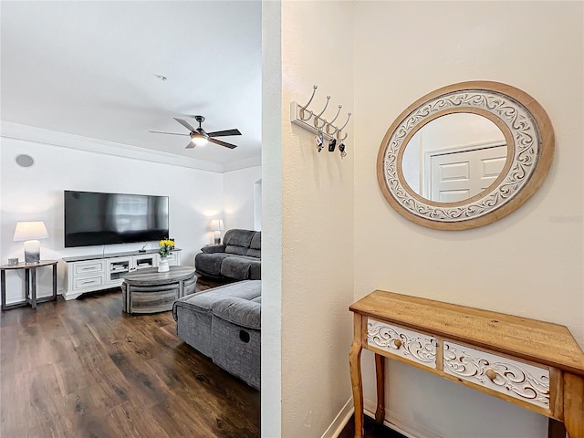 living area with ceiling fan, dark wood-type flooring, and crown molding