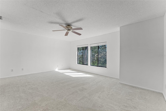 empty room featuring baseboards, carpet, a ceiling fan, and a textured ceiling