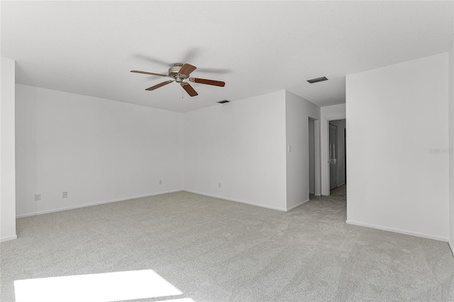 empty room with light carpet, ceiling fan, visible vents, and baseboards