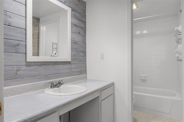 bathroom with toilet, tile patterned floors, wooden walls, and vanity