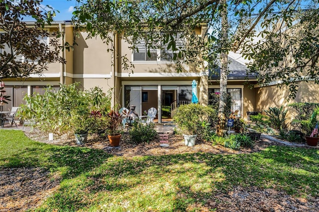 rear view of house with a yard, a patio area, and stucco siding