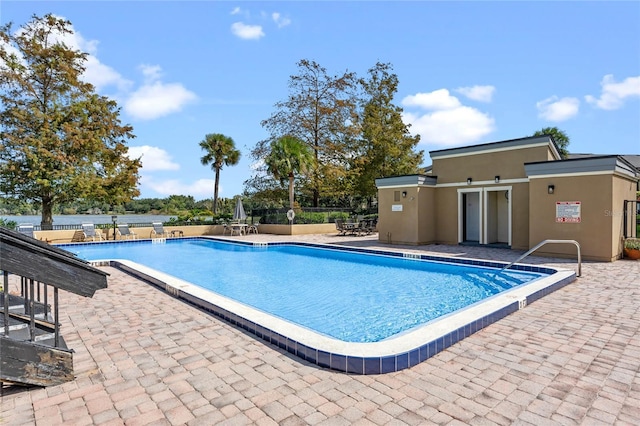 community pool with fence and a patio